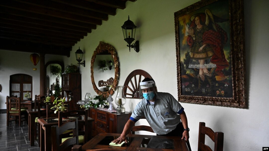 Un hombre limpia una mesa en el área de restaurante de un hotel en Antigua Guatemala, departamento de Sacatepéquez, a 45 km al sureste de la ciudad de Guatemala el 6 de septiembre de 2020.