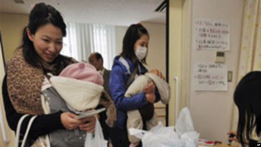 Mothers receive bottled water at a healthcare center in Tokyo as the Tokyo Metropolitan Government starts to distribute three small bottles of water each to an estimated 80,000 families with babies of 12 months or younger. March 24, 2011