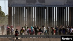 FILE - Migrants queue to request asylum after crossing illegally into El Paso, in this picture taken from Ciudad Juarez, Mexico, April 21, 2019.