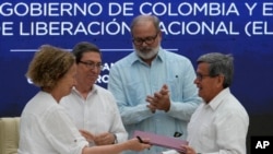 La representante del gobierno colombiano Vera Grabe, izquierda, y el comandante colombiano del grupo guerrillero ELN, Pablo Beltrán, intercambian su acuerdo de extensión del alto el fuego firmado en La Habana, Cuba, el martes 6 de febrero de 2024.