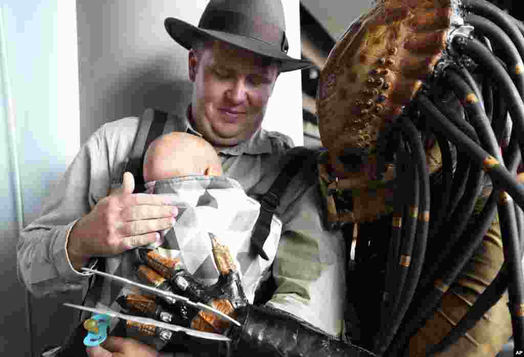 A cosplayer looks at a baby during the Comic Con event in Prague, Czech Republic, Oct. 16, 2021.