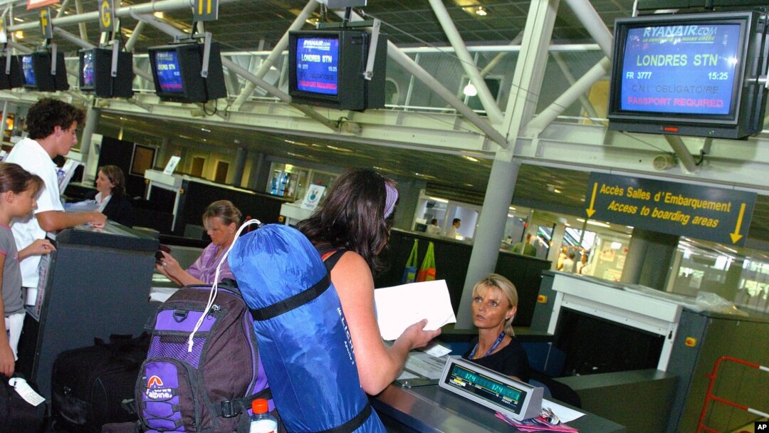 FILE - Passengers en route to London check in at Biarritz airport, southwestern France, Aug. 11, 2006. The U.S. is expected to broaden its ban on in-flight laptops and tablets to include planes from the European Union.