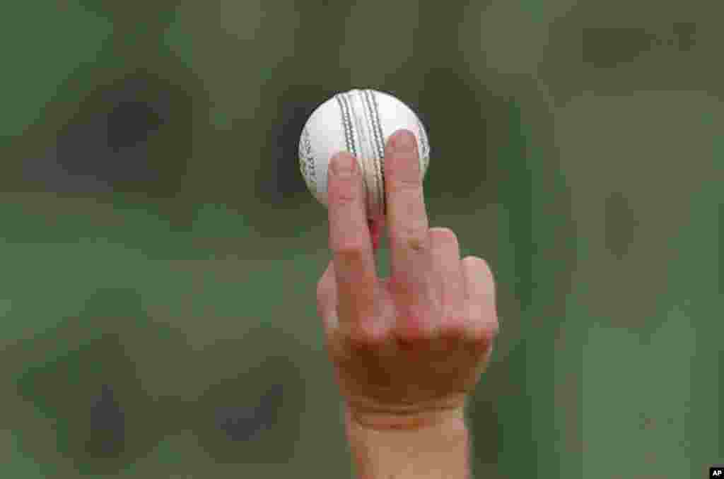 England's cricket player Chris Woakes grips a ball as he practices the swing during a practice session in Colombo, Sri Lanka.