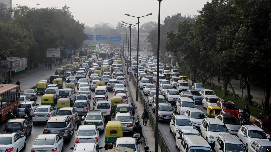 FILE - Vehicles move slowly at a traffic intersection after the end of a two-week experiment to reduce the number of cars to fight pollution in in New Delhi, India, Jan. 16, 2016. 