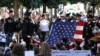 A New York police bagpipe team plays as they stand with an American flag from the World Trade Center during a ceremony marking the 20th anniversary of the September 11, 2001 attacks in New York City, Sept. 11, 2021.