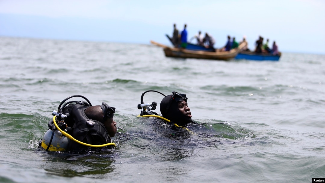 Members of the Uganda Police Marine Unit participate in rescue efforts after a boat carrying mostly Congolese refugees capsized in Lake Albert southwest of Uganda's capital, Kampala, March 23, 2014.