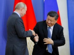 FILE - Chinese President Xi Jinping and Russian President Vladimir Putin shake hands during a ceremony at which Xi was presented with an honorary degree from St. Petersburg State University in St. Petersburg, Russia, June 6, 2019.