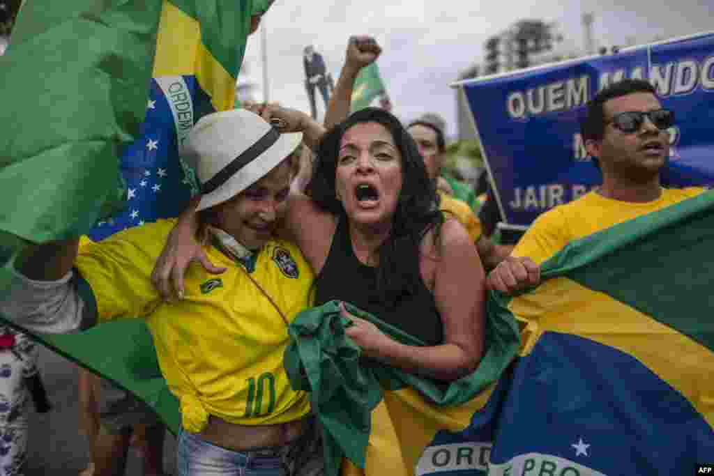 Supporters of Brazilian presidential candidate for the Social Liberal Party (PSL) Jair Bolsonaro cheer in front of the residential condominium where he lives, in Barra da Tijuca, in Rio de Janeiro, Brazil, Oct. 7, 2018, during general elections.