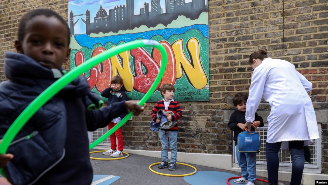 Children use hoops for social distancing at L'Ecole des Petits, an independent French bilingual school, as the coronavirus disease (COVID-19) lockdown eases in Fulham, London, June 9, 2020. 