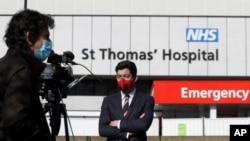 Journalists work outside St Thomas' Hospital in central London as British Prime Minister Boris Johnson was moved to intensive care after his coronavirus symptoms worsened in London, Tuesday, April 7, 2020.