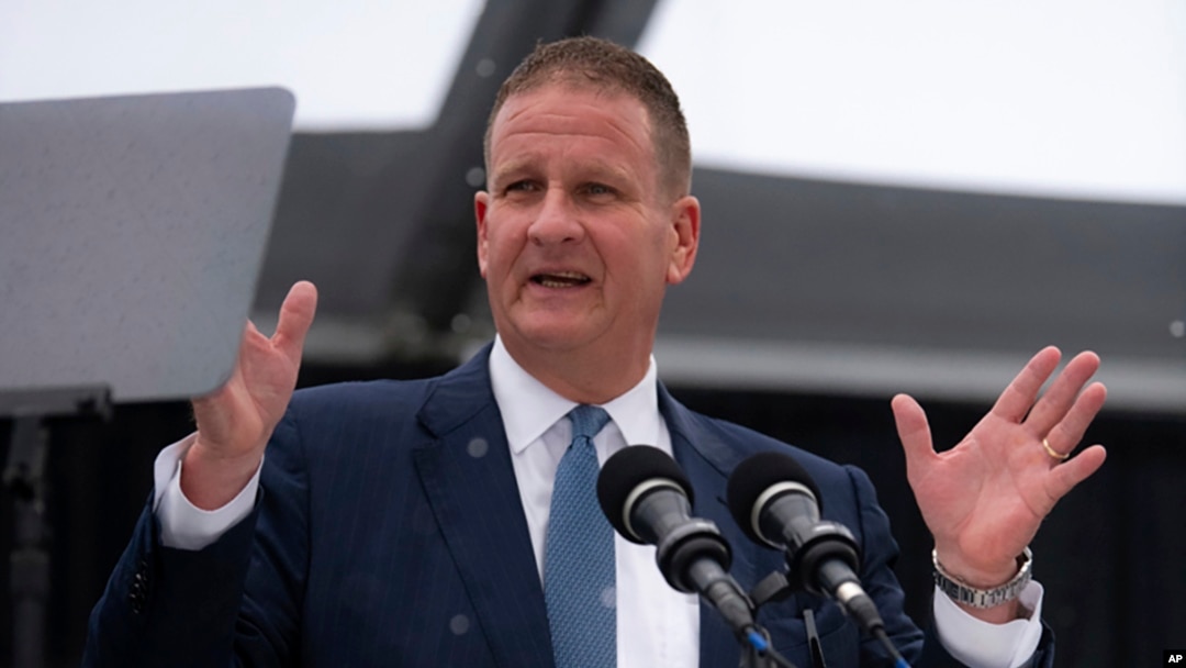 In this photo provided by University of Massachusetts Dartmouth, billionaire Robert Hale speaks at the graduation ceremony May 16, 2024, in Dartmouth, Mass. Hale gifted graduates at the University of Massachusetts Dartmouth each with $1,000, but he asked them to donate $500.