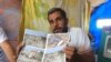 At a refugee camp near Mosul, Ibrahim Makhool holds up pictures of his house that was destroyed in an airstrike against Islamic State militants in December, killing two of his three children, in Hammam Alil, Iraq, June 21, 2017.