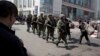 Heavily armed Chinese paramilitary police men march past the site of the April 31 explosion outside the Urumqi South Railway Station in Urumqi in northwest China's Xinjiang Uygur Autonomous Region. Recent deadly attacks in China blamed on Islamic extremi