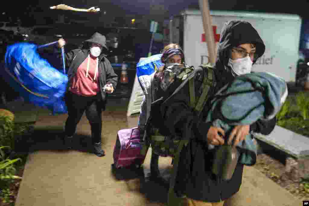People carrying their belongs arrive at an evacuation center in Santa Barbara, Jan. 9, 2023.