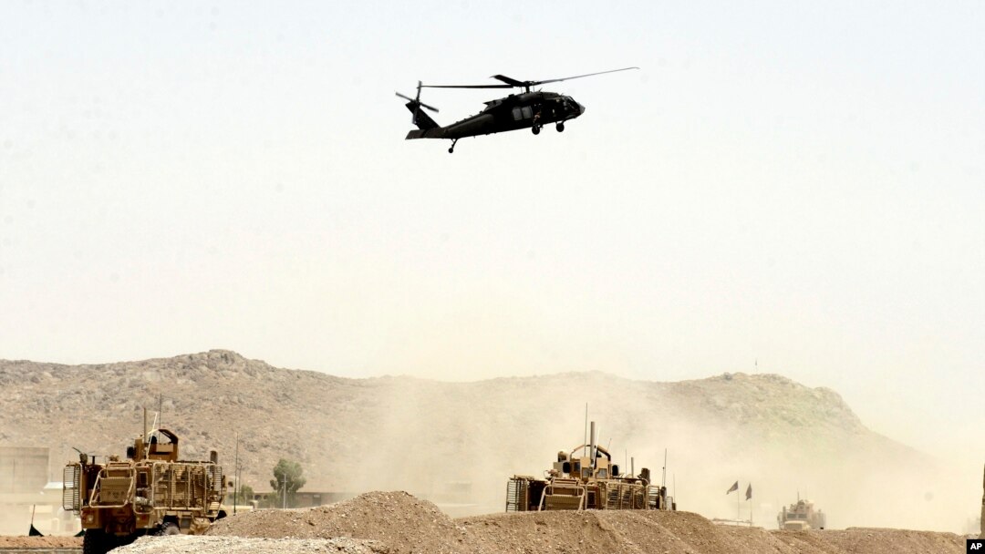 FILE - A US military helicopter flies over the site of a suicide bomb that struck a NATO convoy in Kandahar south of Kabul, Afghanistan, Aug. 2, 2017.
