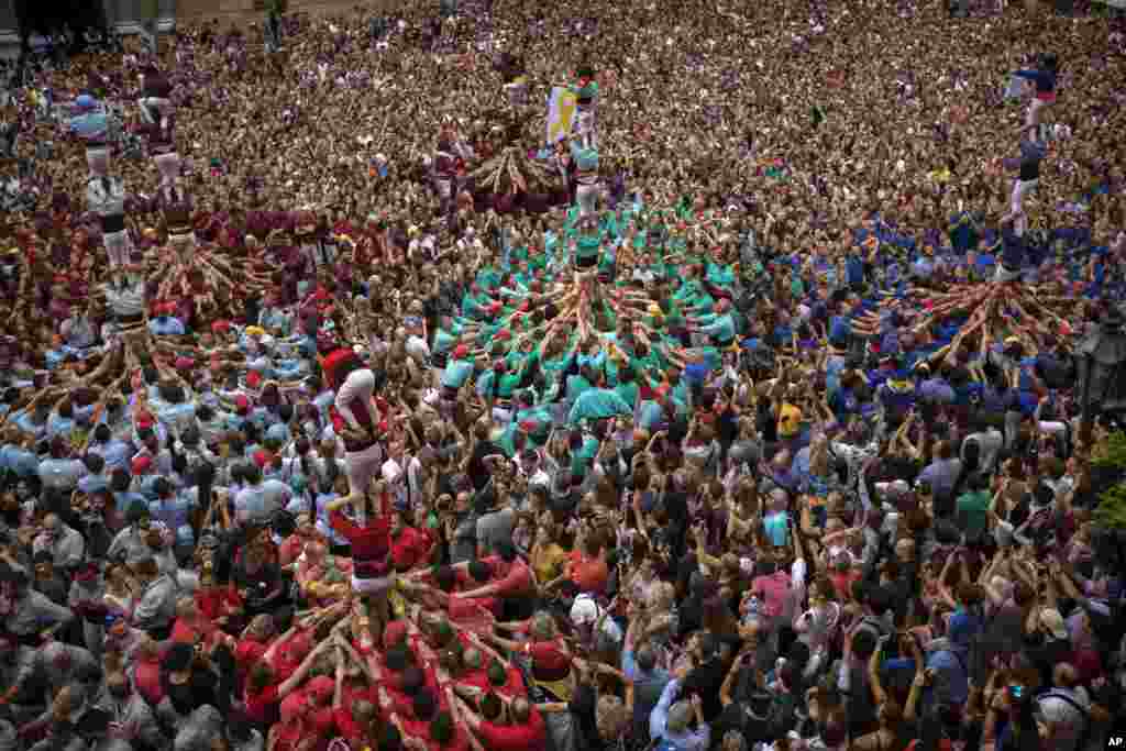 Participants make human towers or "Castellers" during the Saint Merce celebrations in San Jaime square in Barcelona, Spain.