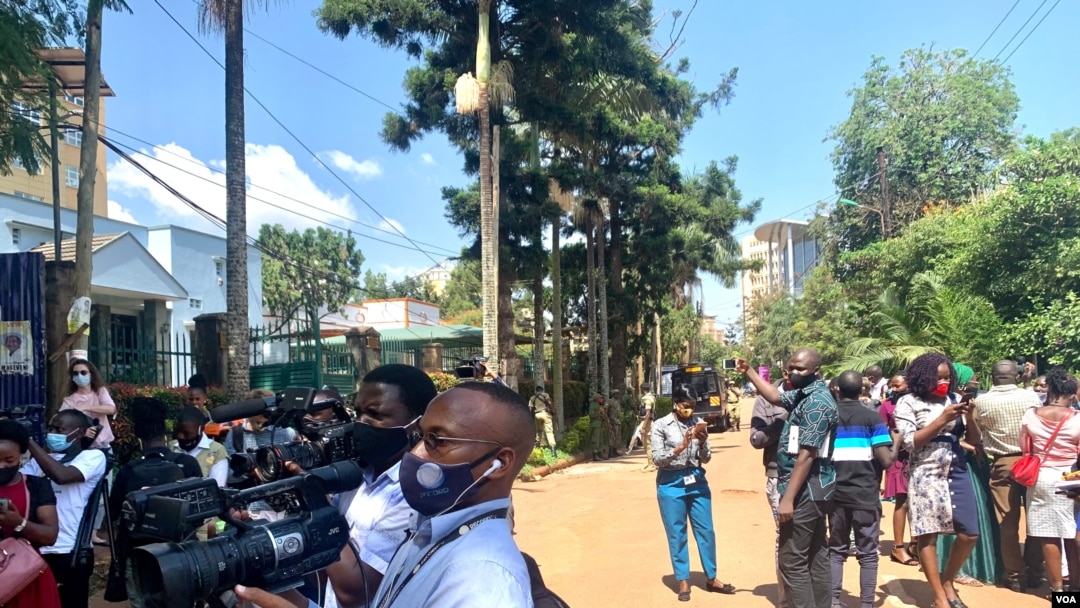 Journalists in Kampala stand in the middle of the road as they cover their protest against Security brutality. (Halima Athumani/VOA)