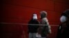 Women wearing face masks and face shields talk on a street, as COVID-19 outbreaks continue in Shanghai, China, Dec. 12, 2022. 
