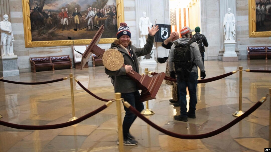 WASHINGTON, DC - JANUARY 06: A pro-Trump protester carries the lectern of U.S. Speaker of the House Nancy Pelosi through the Roturnda of the U.S. Capitol Building after a pro-Trump mob stormed the building on January 06, 2021 in Washington, DC…