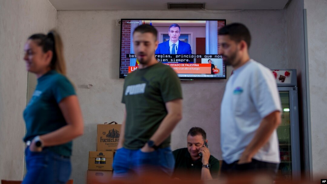 Comensales conversan en un restaurante mientras el primer ministro español, Pedro Sánchez, aparece en una transmisión de televisión el martes 28 de mayo de 2024 para oficializar el reconocimiento a un Estado palestino.