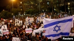 FILE - People take part in a protest against the Israeli government's plan to deport African migrants, in Tel Aviv, Israel March 24, 2018.