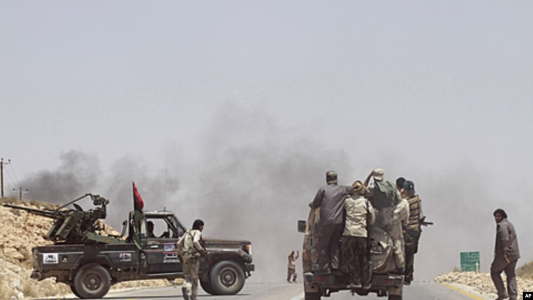Rebel fighters enter the village of Al-Qawalish after a battle to seize control of the town from forces loyal to Libya's leader Moammar Gadhafi, July 6, 2011