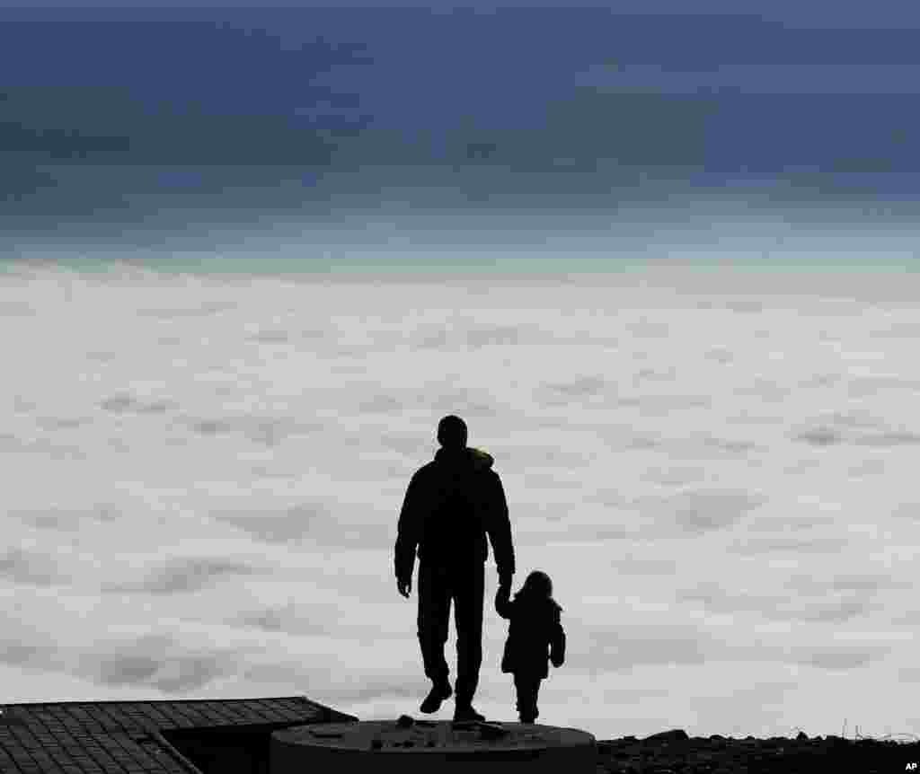 A man with a child walks toward the top of Vodno Mountain in Skopje, Macedonia.