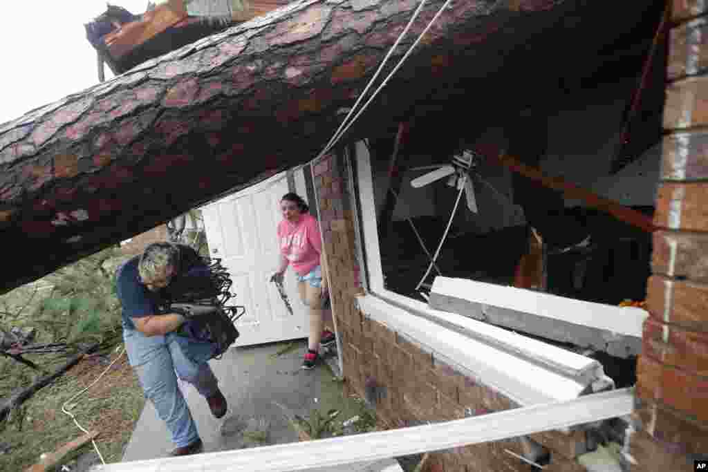 Megan Williams, left, and roommate Kaylee O'Brian take belongings from their destroyed home after several trees fell on the house during Hurricane Michael in Panama City, Florida, Oct. 10, 2018.