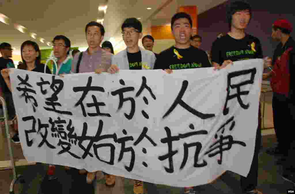 民陣及學聯成員拉起橫額,在李飛出席政改簡介會的亞洲博覽館內示威
