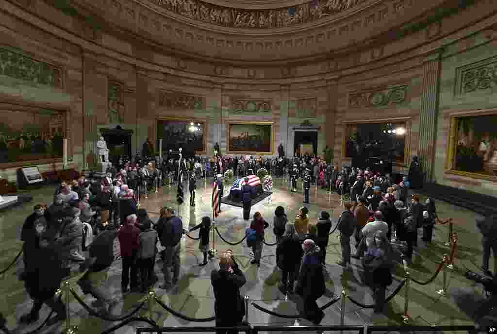 Mourners look at the flag-draped casket of former President Jimmy Carter as he lies in state in the Capitol, in Washington, Jan. 7, 2025.