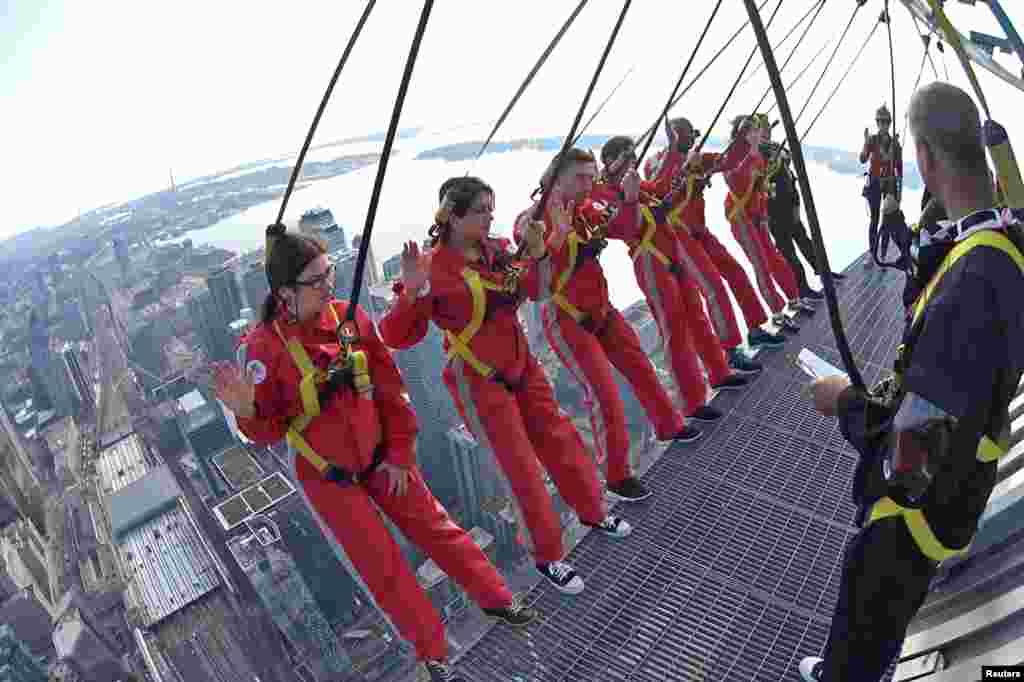 Six new Canadian citizens take their oath of citizenship while harnessed on the CN Tower's "Edgewalk" 356 meters (1,168 feet) above Toronto, Ontario, in a still image from video, Oct. 9, 2018.