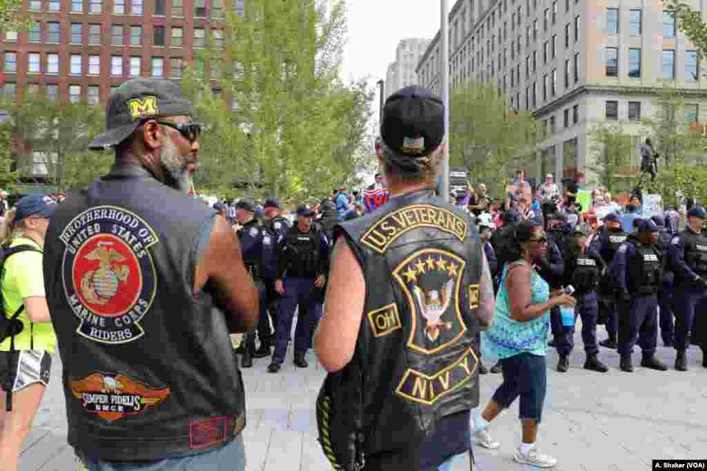 Two men watch as police form a line around protesters at Public Square during the Republican National Convention, in Cleveland, July 21, 2016.