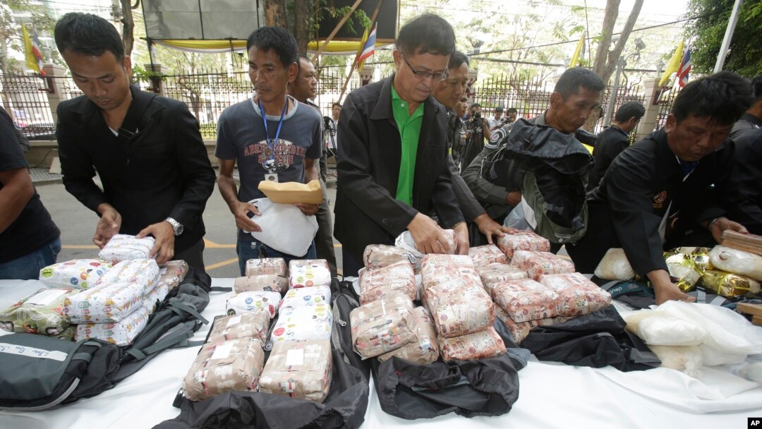 Thai policemen display drugs during a press conference in Bangkok, Thailand on March 24, 2016. They had seized 226 kilograms of crystalline methamphetamine and 8 kilograms of heroin. Thai police have arrested 15 Malaysians.