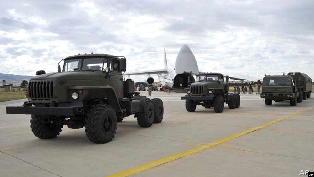 Vehículos militares y equipos, partes del sistema de defensa aérea ruso S-400, son vistos en la pista de aterrizaje al ser descargados de aviones rusos.