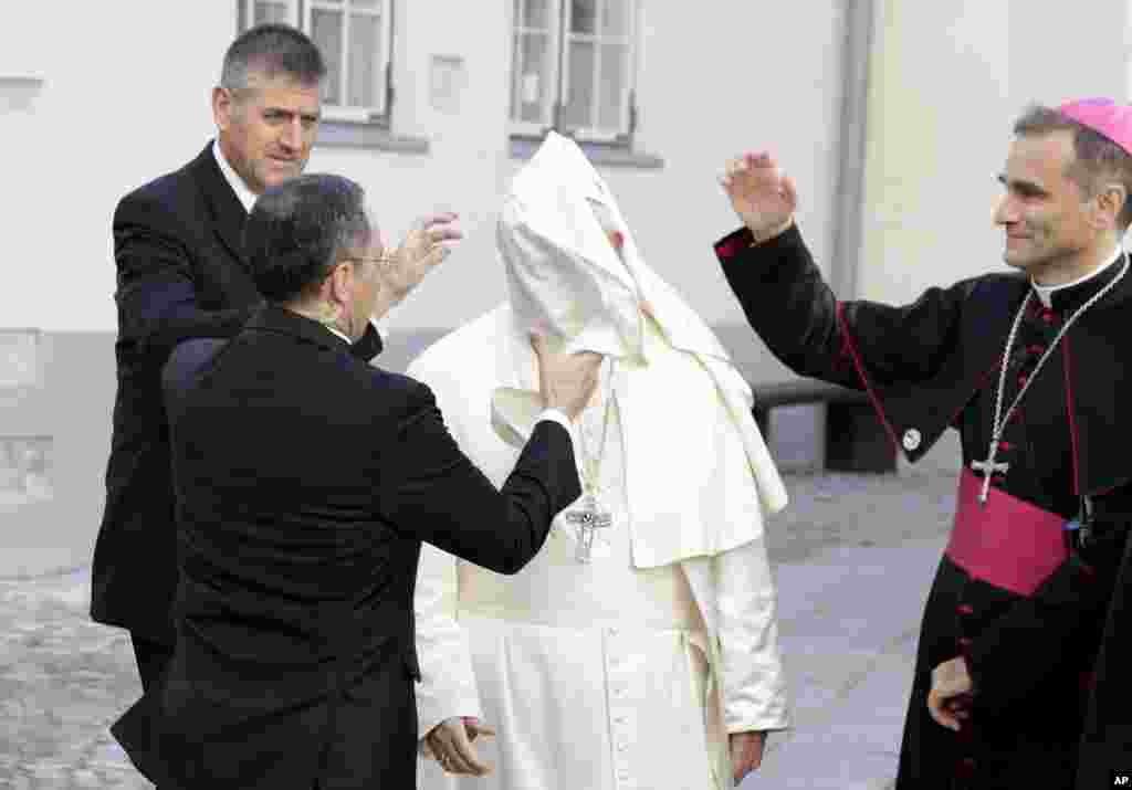 A gust of wind blows Pope Francis' mantle as he arrives to a meeting with people assisted by the church in the Cathedral of Saints Peter and Paul in Tallinn, Estonia.
