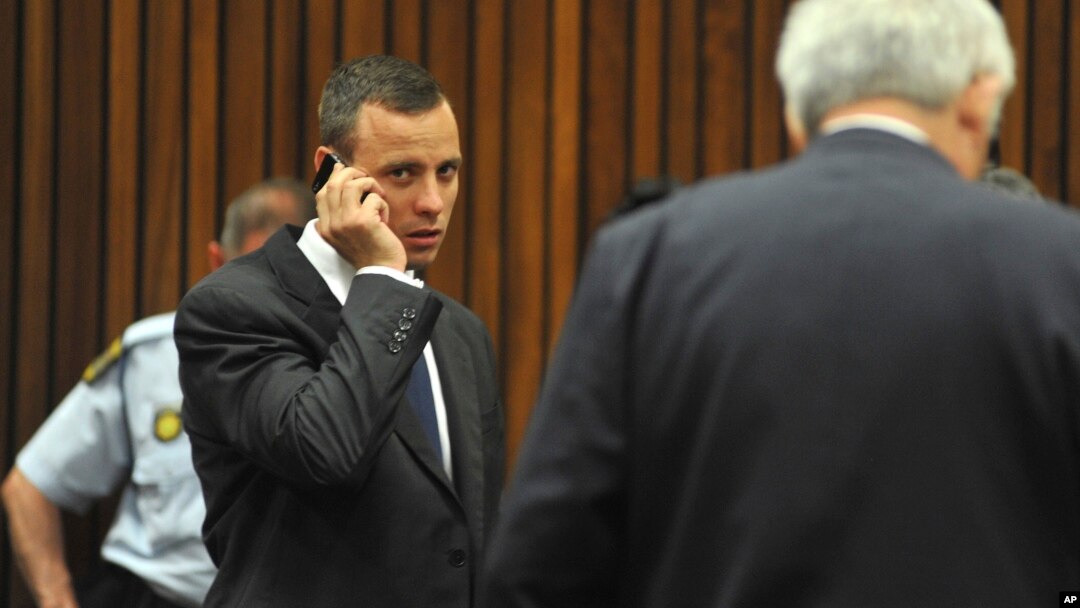 Oscar Pistorius talks on a mobile phone while waiting for proceedings to get under way in court in Pretoria, South Africa, March 24, 2014.