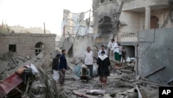 FILE - People inspect the damage of houses destroyed by Saudi-led airstrikes in Sanaa, Yemen, Jun. 9, 2017. 