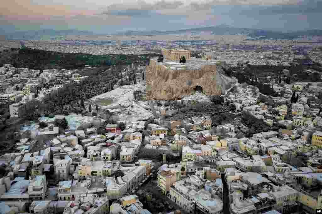 The snow covers some parts of the ancient Acropolis hill and Plaka in the tourist district of Athens, Greece.