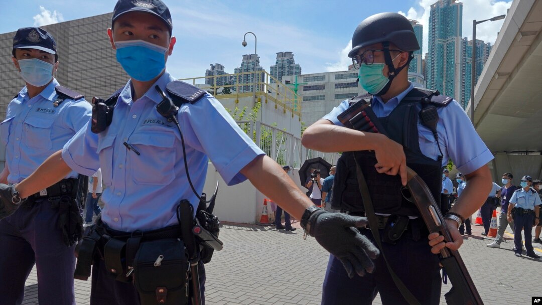 當香港首位被控涉嫌違反國安法的唐英傑坐著輪椅被押解至法院時港警戒備。 （2020年7月6日）当香港首位被控涉嫌违反国安法的唐英杰坐着轮椅被押解至法院时港警戒备。（2020年7月6日）
