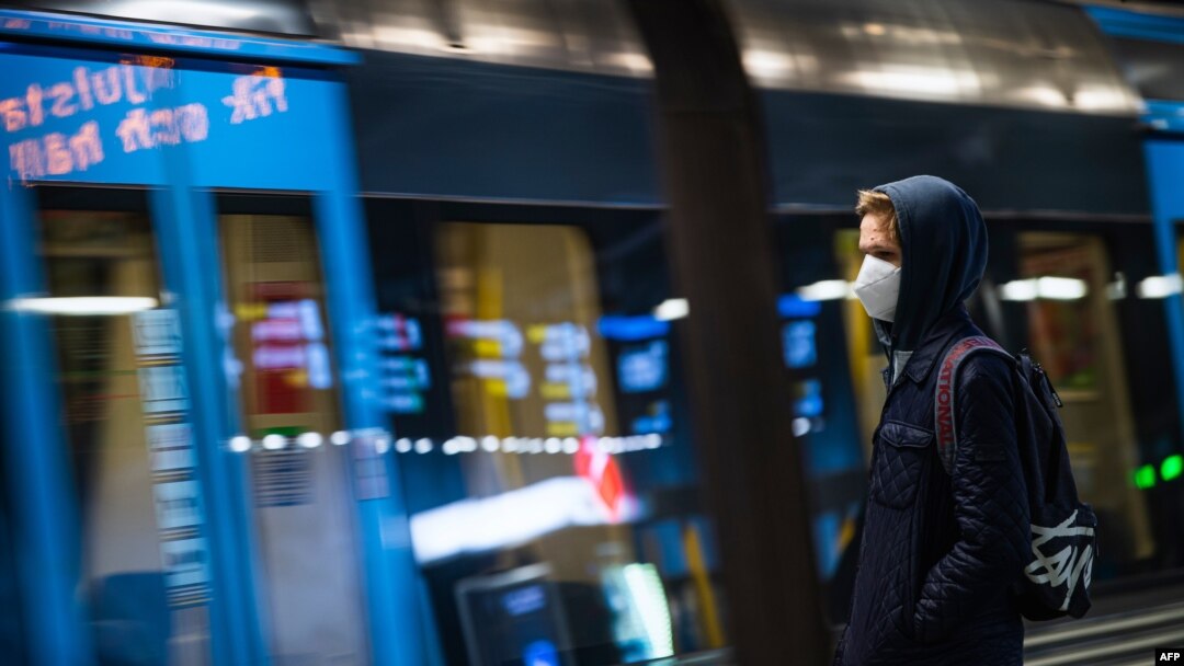 A commuter wearing a protective face mask waits for the metro at Stockholm's central station, Dec. 3, 2020.