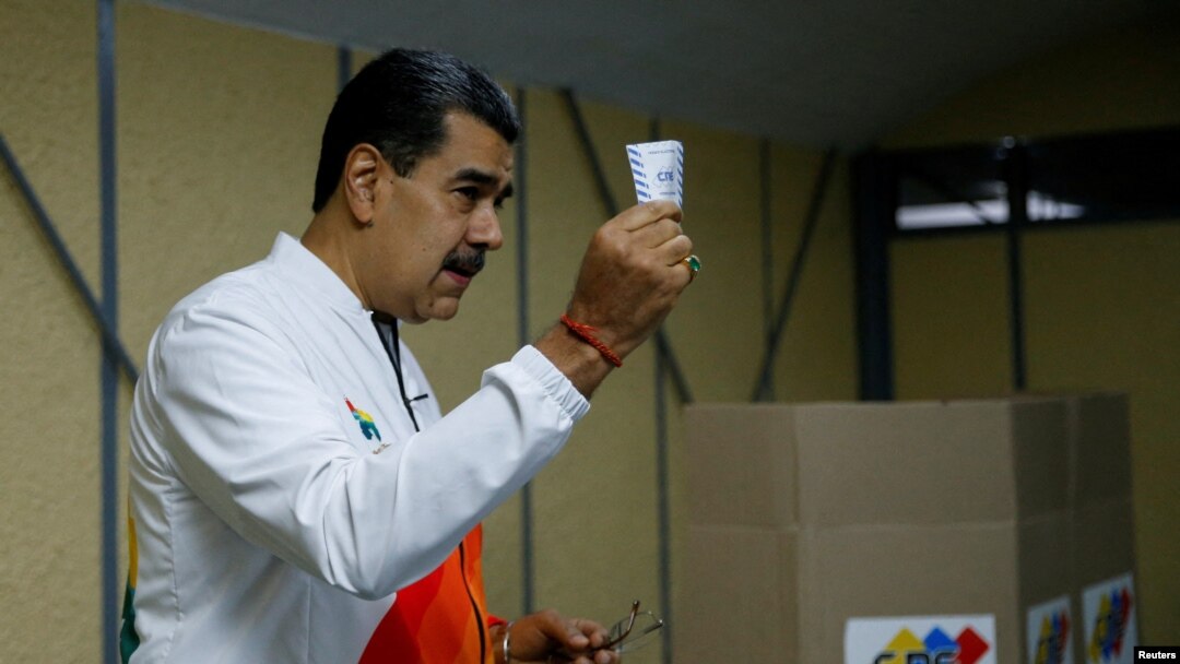 Venezuela's President Nicolas Maduro shows his ballot during an electoral referendum over Venezuela's rights to the potentially oil-rich region of Esequiba, which has long been the subject of a border dispute between Venezuela and Guyana, in Caracas, Venezuela, Dec. 3, 2023