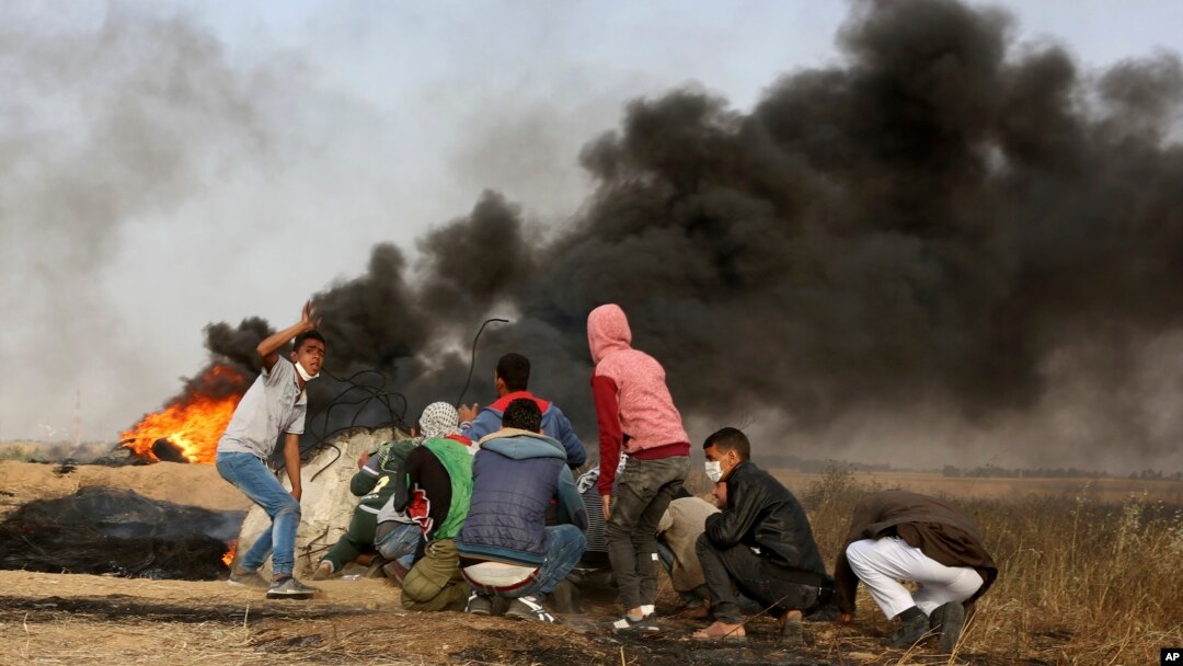 Palestinian protesters take cover during clashes with Israeli troops along Gaza's border with Israel, east of Khan Younis, Gaza Strip, April 5, 2018. A new round of protests along the border is expected Friday.